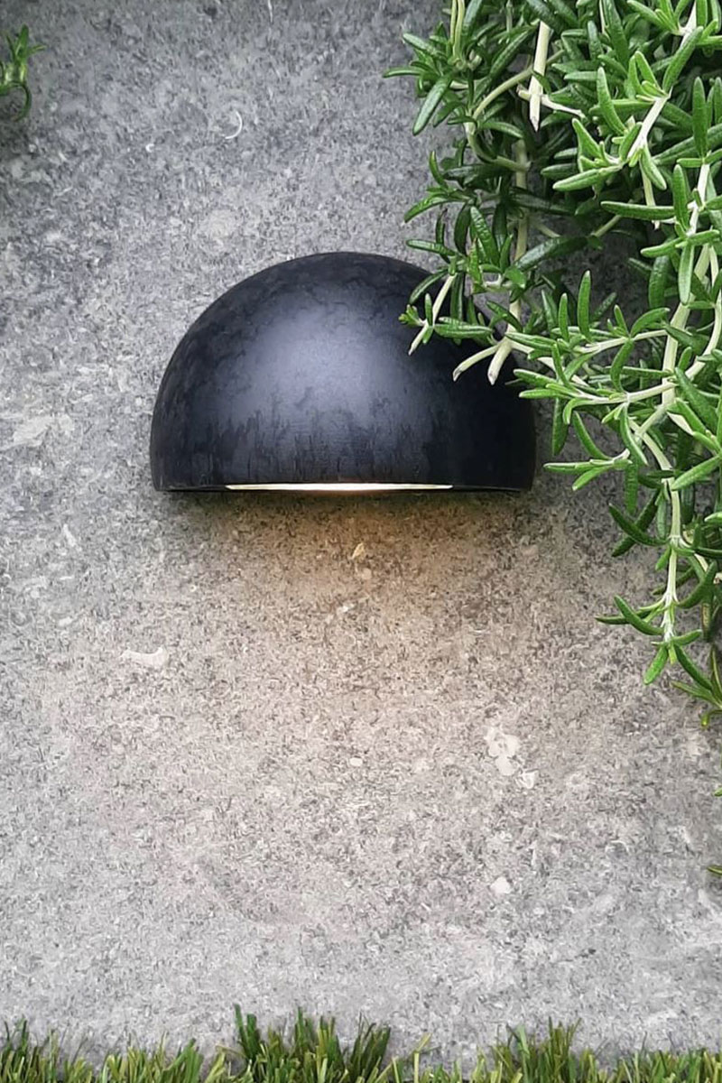 Gardens at Night step light installed on concrete wall with greenery