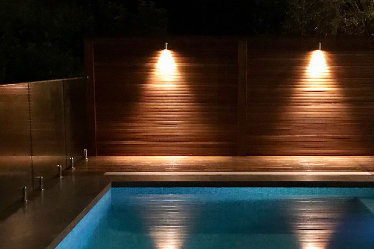 Gardens at Night wall lights illuminating pool area