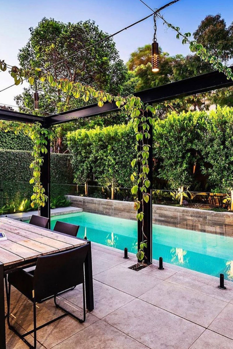 Gardens at Night Hanging Light Speckle overhead light in landscaped alfresco dining by pool