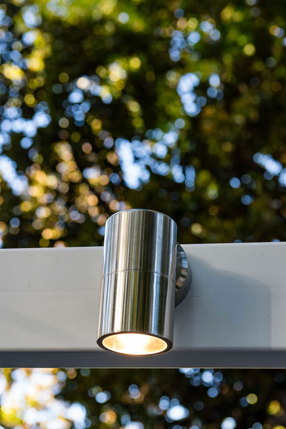 Gardens at Night Wall Light Down installed on pergola illuminating landscaped garden