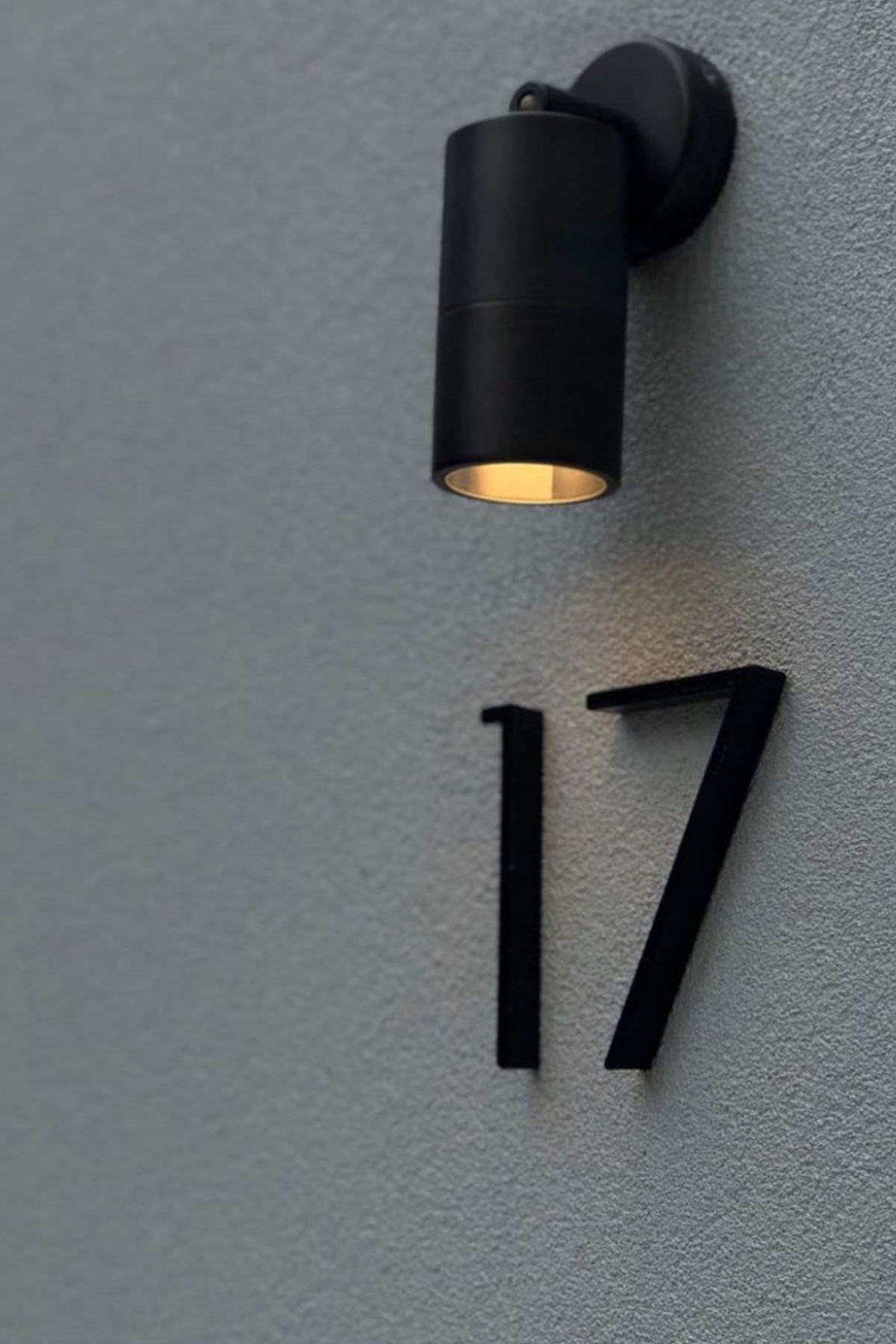 Gardens at Night wall light illuminating house number on front wall of residential house